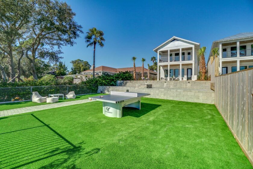 green grass and ping pong and seating area out back